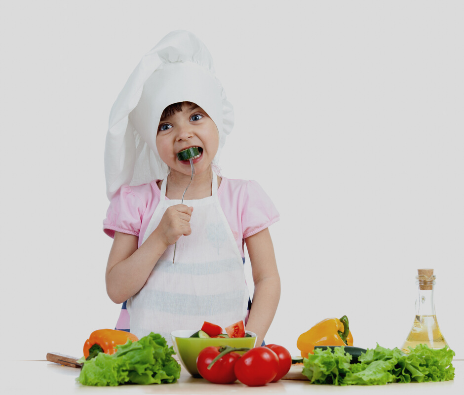 Chef kid preparing and tasting healthy food